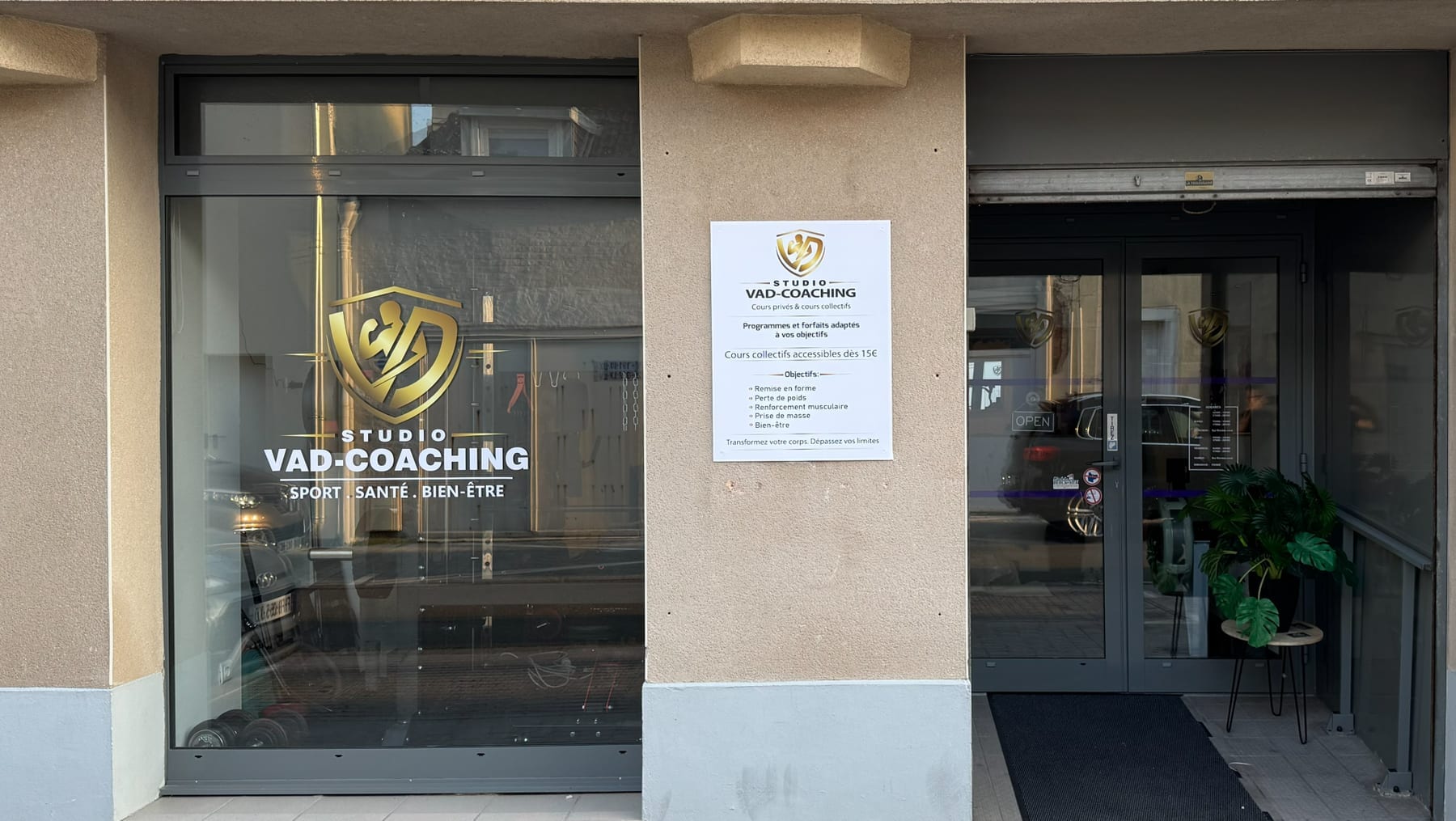 Vitrine d'un studio de sport : logo doré et nom du studio posés en adhésif sur la vitre