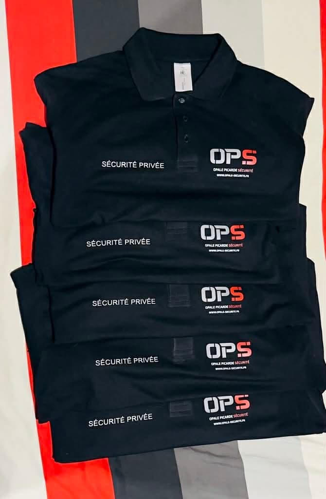Pile de polos noirs floqués d'un logo en couleur et de la mention Sécurité privée