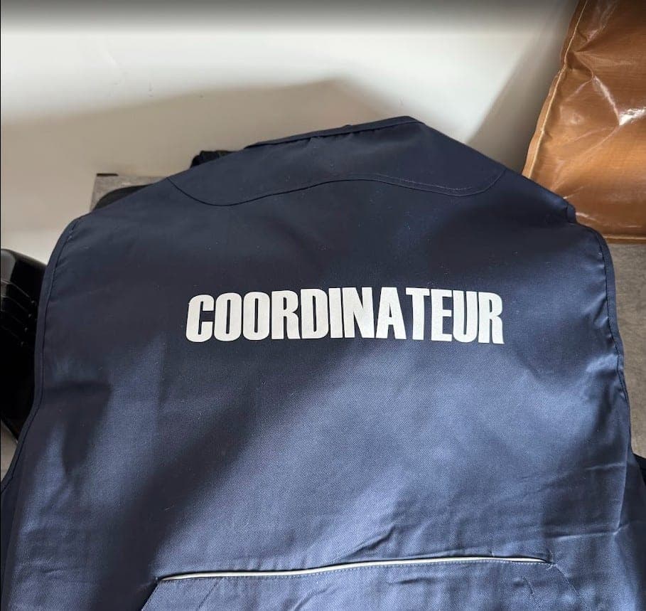 Dos d'une veste marine floquée du mot Coordinateur